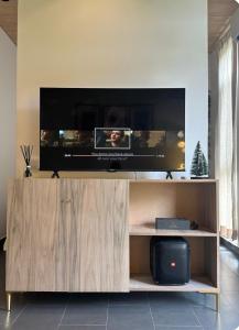 een flatscreen-tv op de top van een houten entertainmentcentrum bij A chic apartment by Afra Paje in Paje