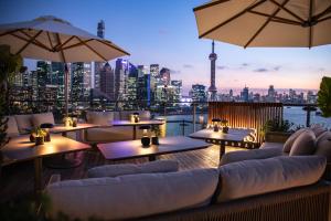 a restaurant with tables and chairs and a city skyline at Banyantree Shanghai On the Bund - Tales rooftop bar boasts a jaw-dropping panoramic vista in Shanghai