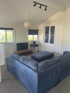 Una sala de estar con un sofá azul y una mesa. en 55 See Street Bargara, en Bargara