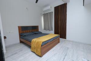 a bedroom with a bed with a wooden headboard at Cozy 2BR in Chennai
