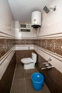 a bathroom with a toilet and a blue bucket at Cozy 2BR in Chennai