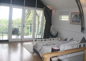 a bedroom with a bed and a large window at SEAVIEWS Oak Beach in Oak Beach
