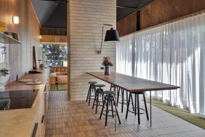 a kitchen with a wooden table and some stools at The Heads Bath House in Barwon Heads
