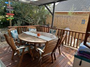 une table et des chaises en bois sur une terrasse dans l'établissement Twilight Cottage, à Plettenberg Bay