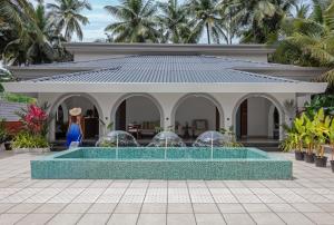 a house with a swimming pool in front of a building at Lamrin Morjim Goa in Morjim
