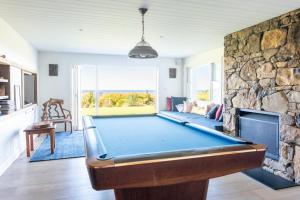 - un billard dans le salon doté d'un mur en pierre dans l'établissement Escarpment House-28 Old Byron Bay Road, Newrybar, à Newrybar 9 autres photos
