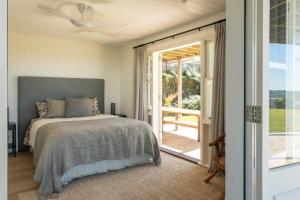 une chambre avec un lit et une porte coulissante en verre dans l'établissement Escarpment House-28 Old Byron Bay Road, Newrybar, à Newrybar