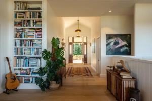 un couloir avec des étagères remplies de livres dans l'établissement Escarpment House-28 Old Byron Bay Road, Newrybar, à Newrybar