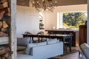 une salle à manger et une cuisine avec une table et des chaises dans l'établissement Escarpment House-28 Old Byron Bay Road, Newrybar, à Newrybar