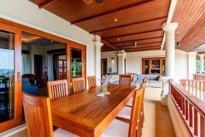 une salle à manger avec une table et des chaises en bois dans l'établissement Luxurious Phuket Escape - Lakewood Hills, à Layan Beach