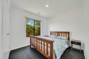 a bedroom with a bed and a window at Modern Comforts in a Spacious 3BR Family Retreat in Rockbank
