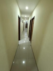 a hallway of a building with white walls and doors at Sapphire Guest House in Kolkata