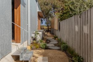 a garden path between a fence and a house at The Heads Bath House in Barwon Heads