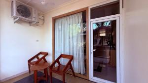 a room with two chairs and a sliding glass door at Maitree Beach Resort in Arambol