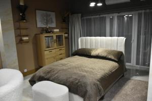 Un dormitorio con una cama, una silla y una ventana en Vinetas Apartments Nr3 The One, en Cēsis