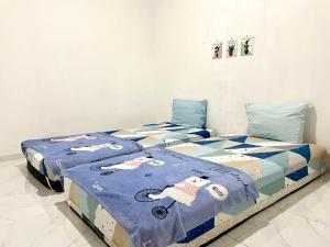 a bedroom with two beds with hello kitty blankets at Dehome Suko Syariah in Surabaya
