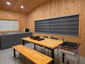 a large screen in a kitchen with a table and benches at Stay33 Pet friendly house near Hwangridangil in Gyeongju