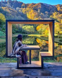 a person sitting on a bench in front of a painting at 47 - Snow Village Cozy Lodge Yuzawa in Yuzawa