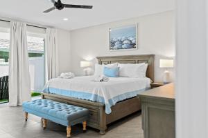 a white bedroom with a bed and a blue stool at 50 8th Avenue in Indialantic +55 photos
