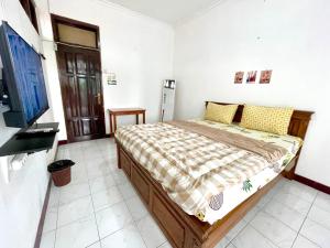 a bedroom with a bed and a flat screen tv at Dehome Suko Syariah in Surabaya +12 photos