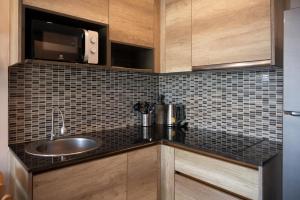 a kitchen with a sink and a microwave at Babylone Sky Garden 206 - 1 BR condo - 2 pools & gym - seaview in Rawai Beach