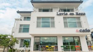 un bâtiment blanc avec un panneau dessus dans l'établissement Gyeongju La Vie en Rose, à Tongnyŏng
