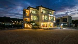 un grand bâtiment avec beaucoup de fenêtres la nuit dans l'établissement Gyeongju La Vie en Rose, à Tongnyŏng 8 autres photos