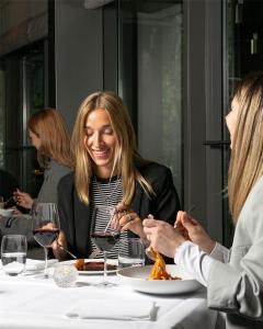 a woman sitting at a table with a plate of food at Grand Hyatt Berlin in Berlin