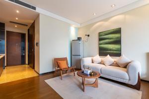 een woonkamer met een bank en een tafel bij Aixin Yangtze River International Apartment in Chongqing