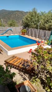 a swimming pool with a bench next to a fence at Finca La Piedra Holidays in Alora