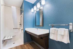 a bathroom with a sink and a mirror at WoodSpring Suites Tamarac in Tamarac +17 photos