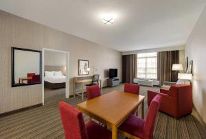 a hotel room with a table and chairs and a bed at Country Inn & Suites by Radisson, Findlay, OH in Findlay