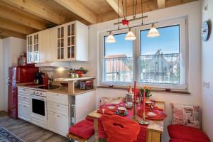 a kitchen with a table and red chairs in a kitchen at Haus Himmelblick mit privater Sauna in Sasbach am Kaiserstuhl