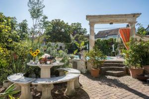 a garden with a stone table with flowers and plants at Haus Himmelblick mit privater Sauna in Sasbach am Kaiserstuhl