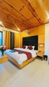 ムスーリーにあるAman's Peak & Plate- Near Jw Marriott Mussorieの木製の天井と大きなベッドのある寝室