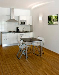 a kitchen with a table and chairs in a room at Villa Treccani Apartments in Malcesine +100 photos