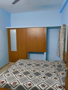 a bedroom with a bed and wooden cabinets at KHS Keshav-U in Ambāsamudram