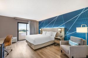 a hotel room with a bed and a chair at Comfort Inn & Suites Arlington Heights - Buffalo Grove in Arlington Heights +33 photos