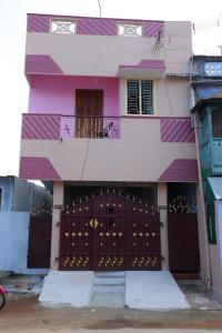 a pink and purple building with a large gate at KHS Keshav-U in Ambāsamudram