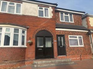 a brick house with a black door and windows at Family Room on Green road in Dudley