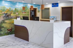 a reception desk with a painting of a camel at Baymont by Wyndham Lancaster PA Dutch Country in Lancaster