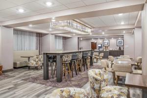 St. PaulにあるRamada by Wyndham St Paul ABの椅子とテーブル付きの客室内のバー