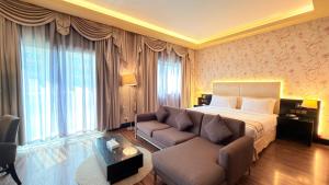 a hotel room with a bed and a couch at Sunday Mangrove Corniche Hotel, Ras Al Khaimah in Ras al Khaimah