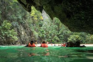 een groep mensen in het water op een strand bij Langkao Homestay Kohlibong หลังเขาโฮมสเตย์ เกาะลิบง in Ko Kwang +6 foto's