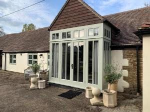 アビンドン・オン・テムズにあるThe Byre, at Cradle Barn offering a king suiteのコンサバトリー付きの家屋延長