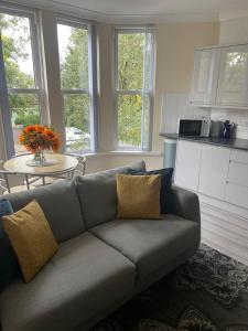 a living room with a couch and a table at Penarth Station Renovated apartment in Cardiff