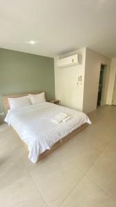 a bedroom with a large bed with white sheets at POP Heritage Residence in Bangkok