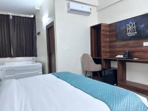 a bedroom with a bed and a desk and a chair at Abharam Retreats in Ghaziabad