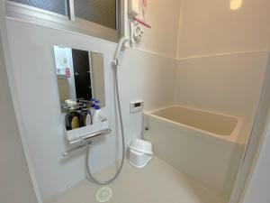 un bagno con doccia, lavandino e specchio di e101 阿佐ヶ谷ローズハウス a Tokyo Altre 22 foto