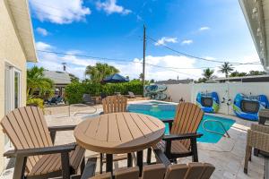 a patio with a table and chairs next to a pool at 445 Watts Way in Cocoa Beach